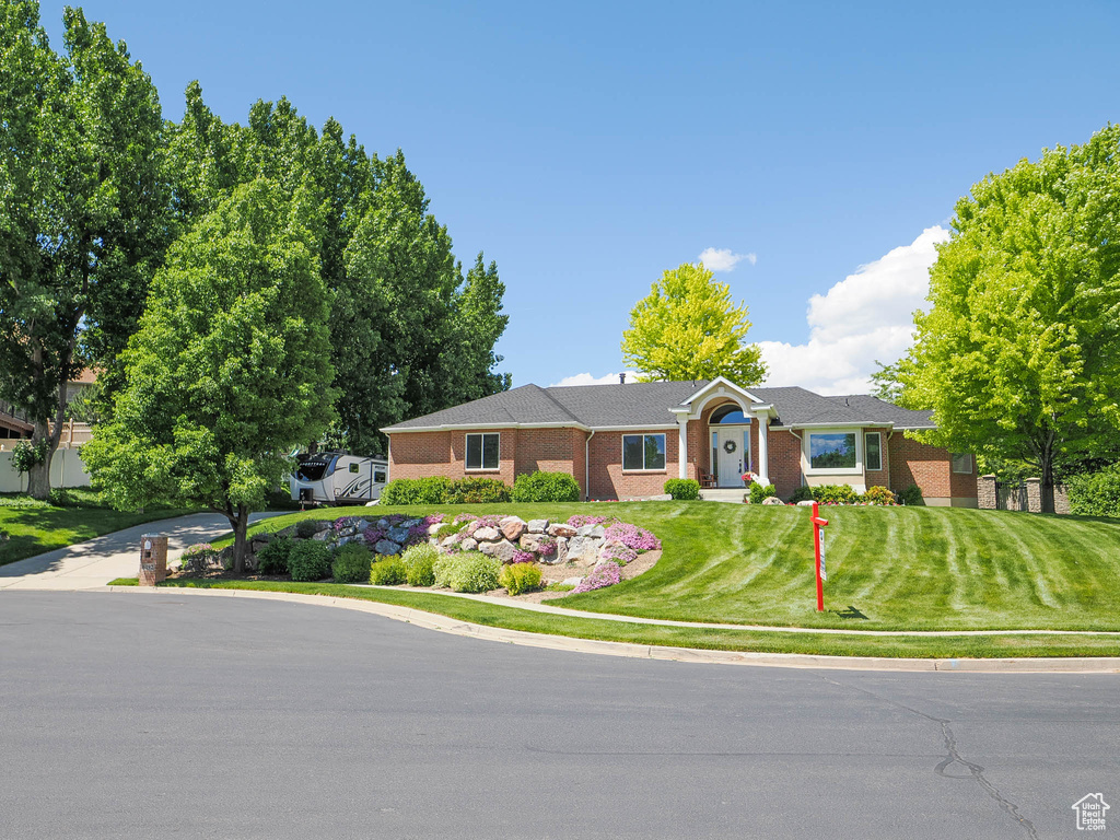 Single story home featuring a front lawn and brick siding