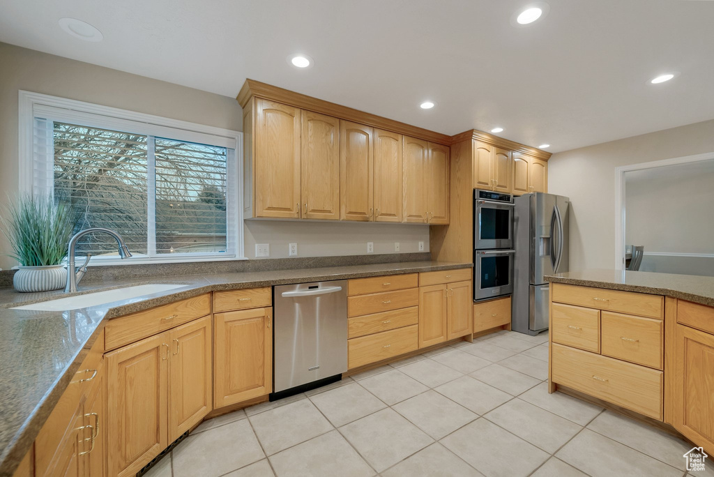 Kitchen featuring stainless steel appliances, a sink, light brown cabinets, recessed lighting, and light tile patterned flooring