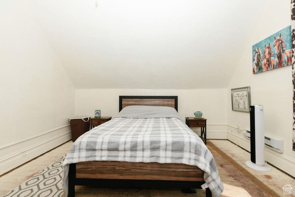 Bedroom with vaulted ceiling and wood finished floors