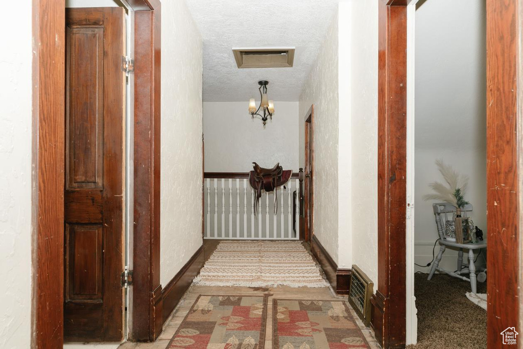 Corridor featuring a textured ceiling
