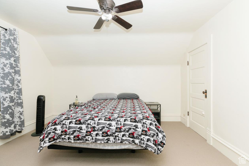 Bedroom featuring vaulted ceiling, carpet floors, and a ceiling fan