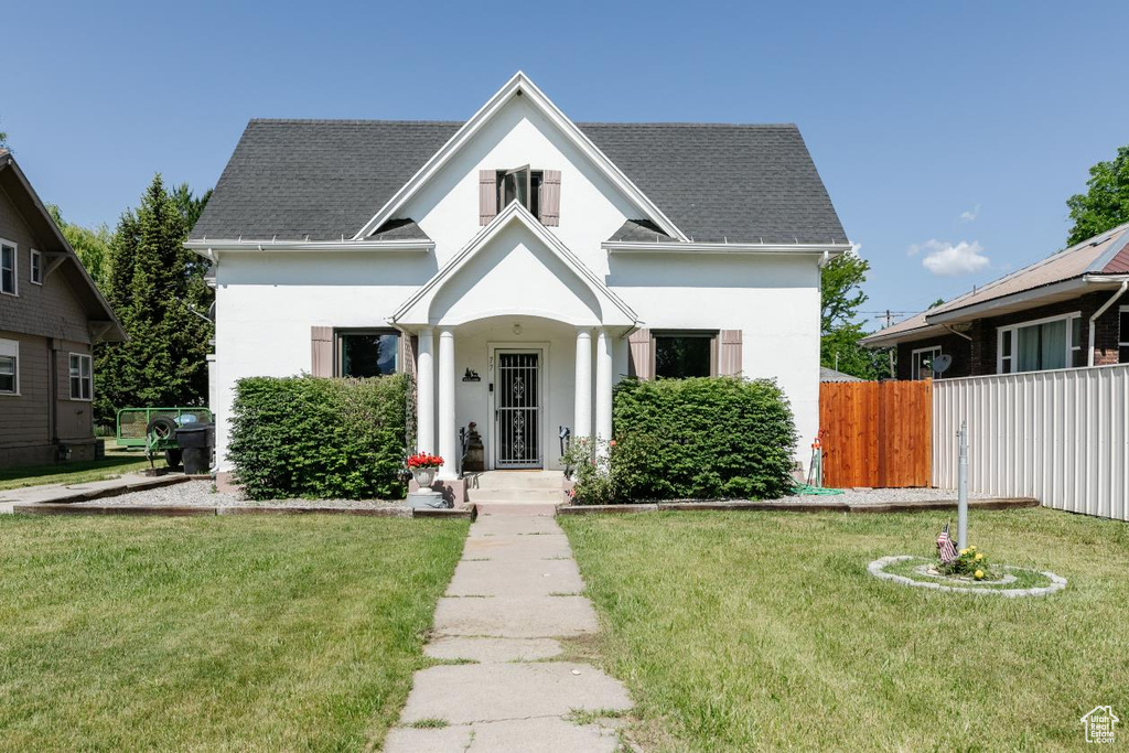 View of front facade with stucco siding and a shingled roof