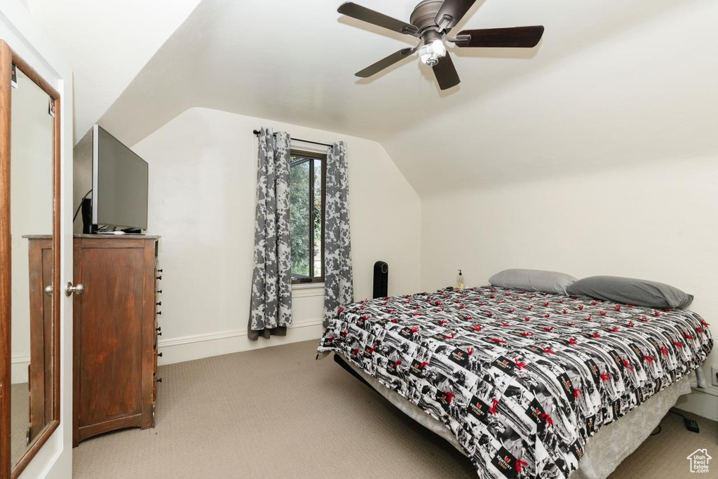 Bedroom featuring carpet, vaulted ceiling, a ceiling fan, and baseboards