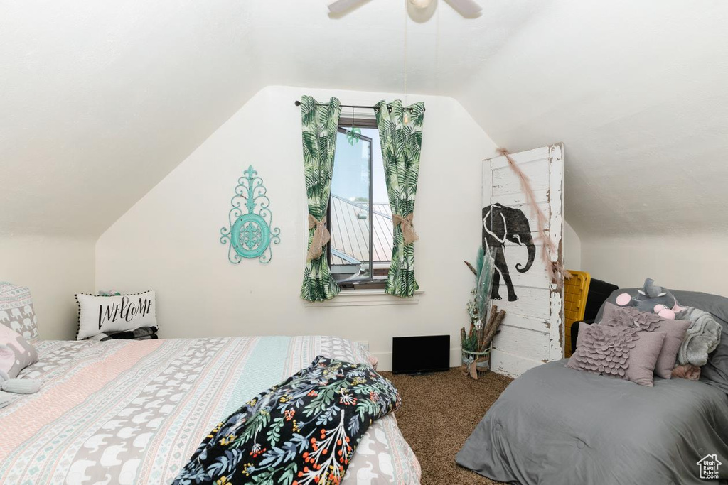 Carpeted bedroom featuring lofted ceiling and a ceiling fan