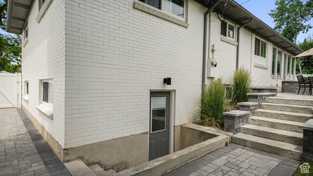 View of side of property with brick siding and a gate