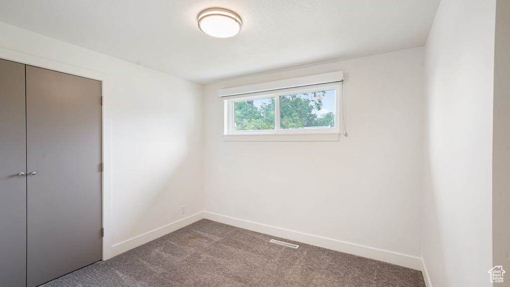 Unfurnished bedroom featuring baseboards, carpet floors, and a closet