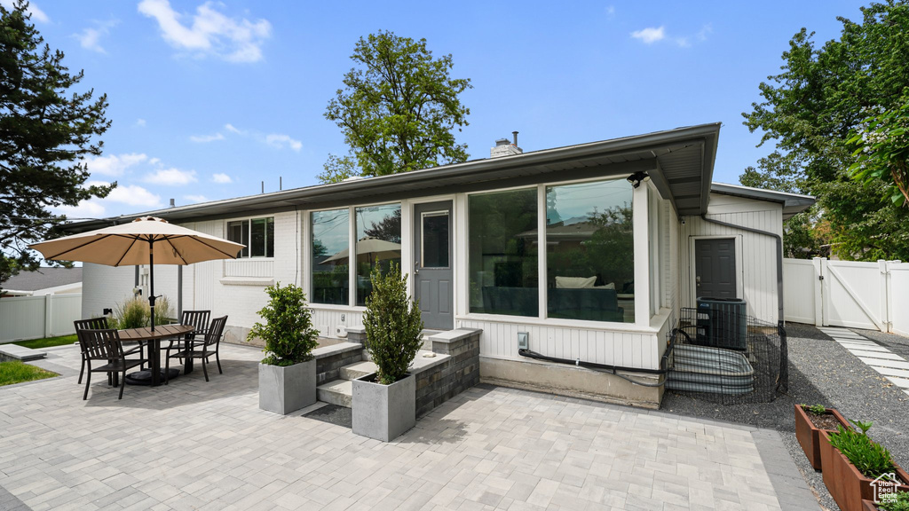 Rear view of property featuring a patio area, a gate, and a chimney
