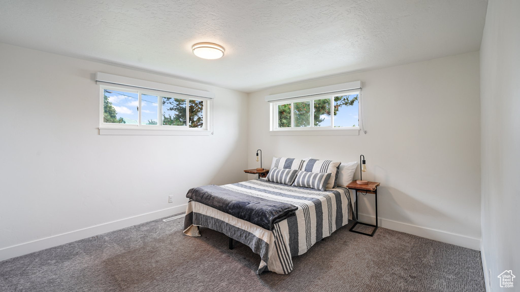 Bedroom with baseboards and dark carpet