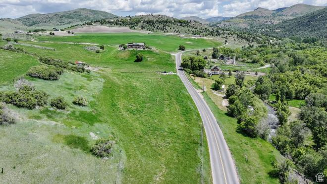 Aerial view of property and surrounding area featuring a mountain backdrop