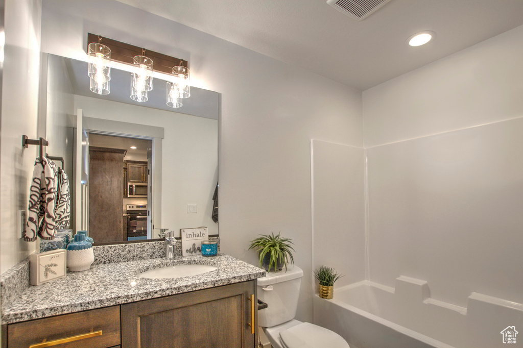 Bathroom featuring vanity, toilet, recessed lighting, and washtub / shower combination
