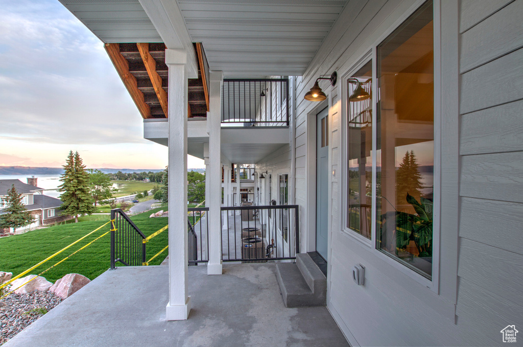 Patio terrace at dusk with a balcony and a lawn
