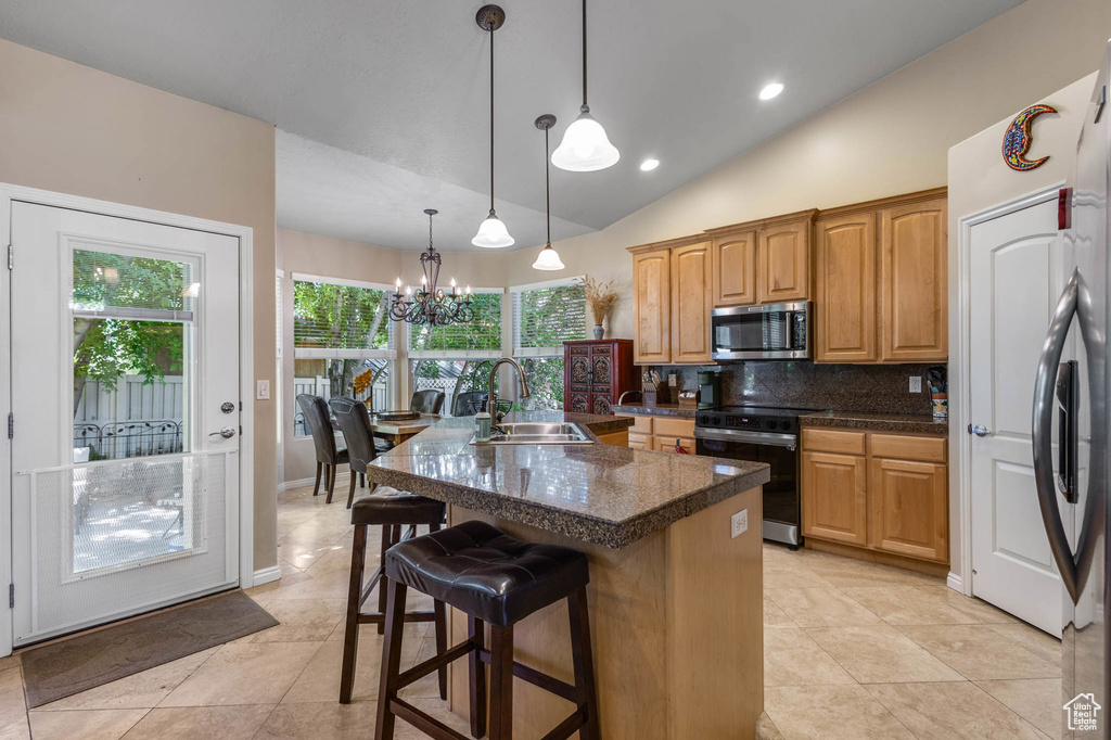 Kitchen with black range with electric stovetop, stainless steel microwave, a sink, a chandelier, and plenty of natural light