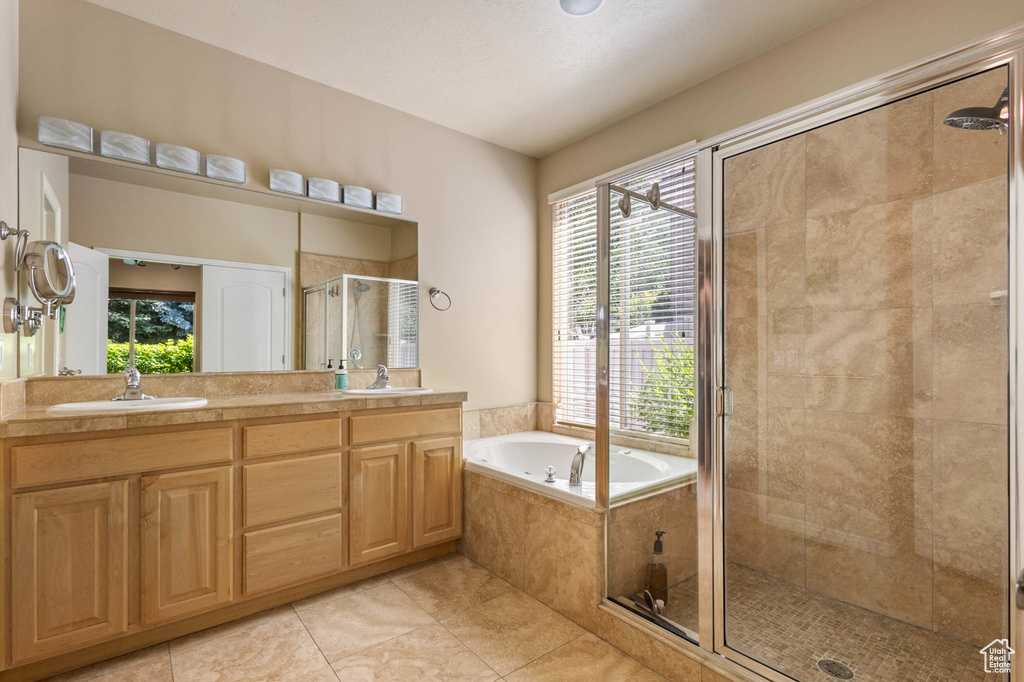 Bathroom with a stall shower, healthy amount of natural light, and tile patterned floors