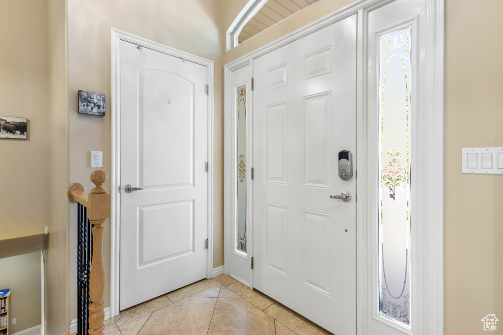 Entryway with light tile patterned floors and baseboards