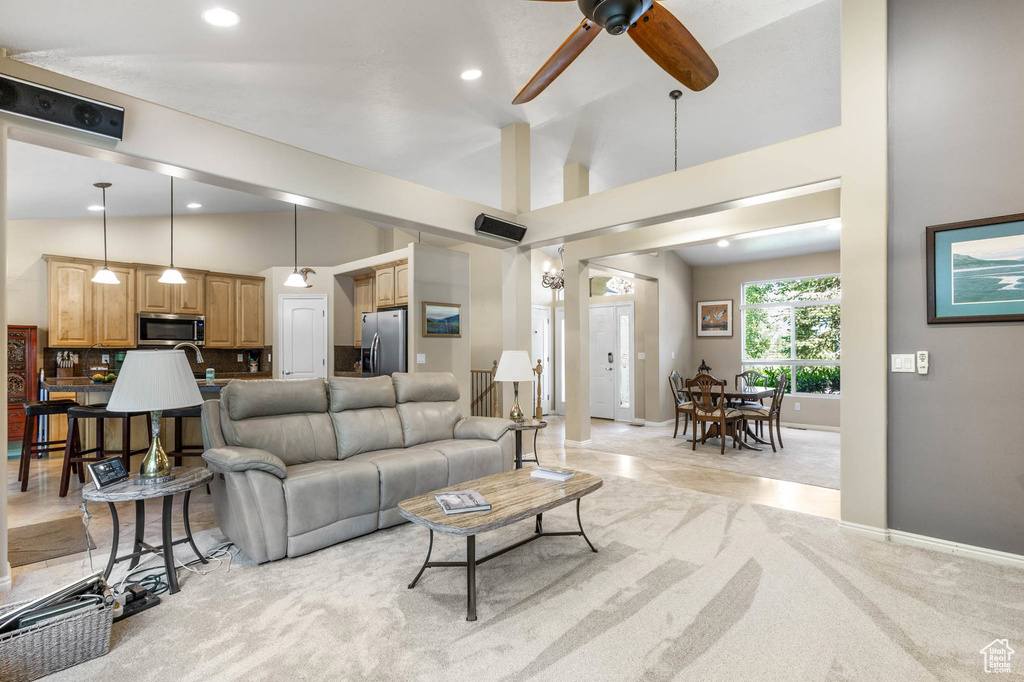 Living room featuring ceiling fan, light colored carpet, lofted ceiling, recessed lighting, and baseboards