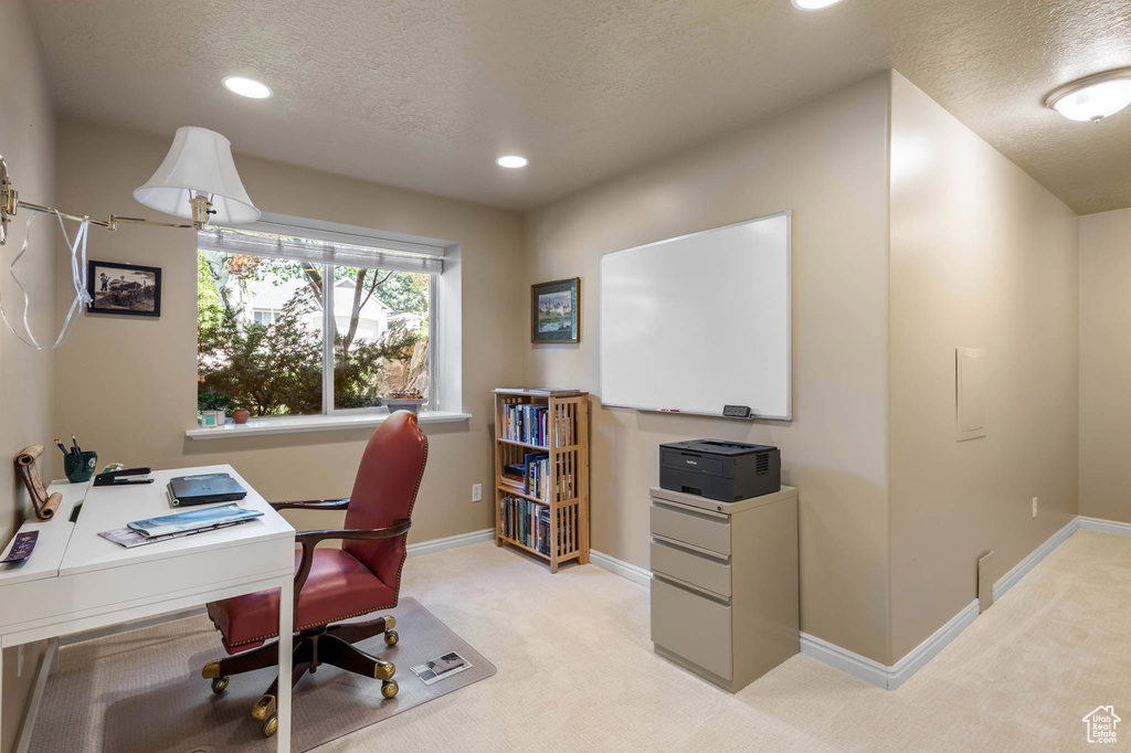 Office space featuring a textured ceiling, light carpet, recessed lighting, and baseboards