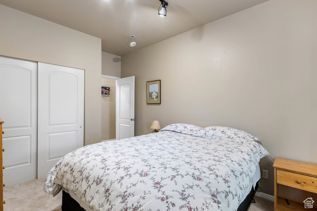 Bedroom featuring light colored carpet and a closet