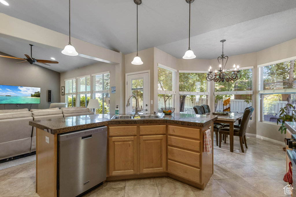 Kitchen featuring stainless steel dishwasher, a sink, tile countertops, ceiling fan, and hanging light fixtures