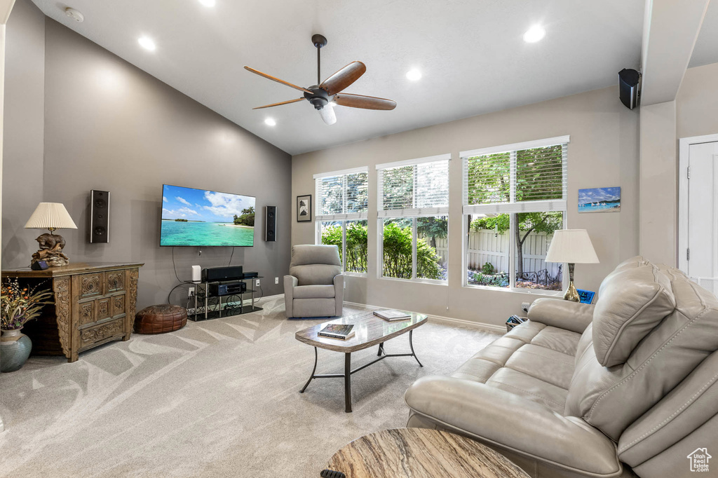 Carpeted living room featuring vaulted ceiling, a ceiling fan, baseboards, and recessed lighting