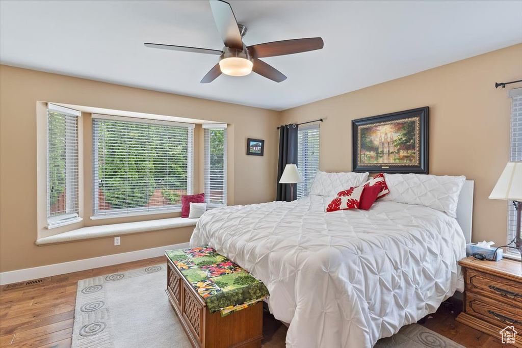 Bedroom featuring wood finished floors, baseboards, and a ceiling fan