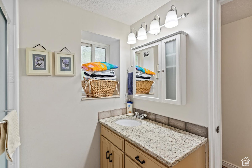 Bathroom featuring vanity and a textured ceiling