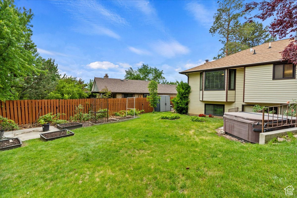 View of yard featuring a garden and a hot tub