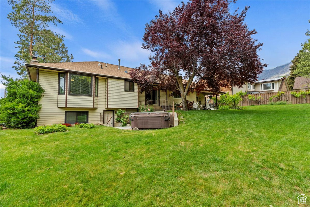 Rear view of property with a hot tub and a chimney