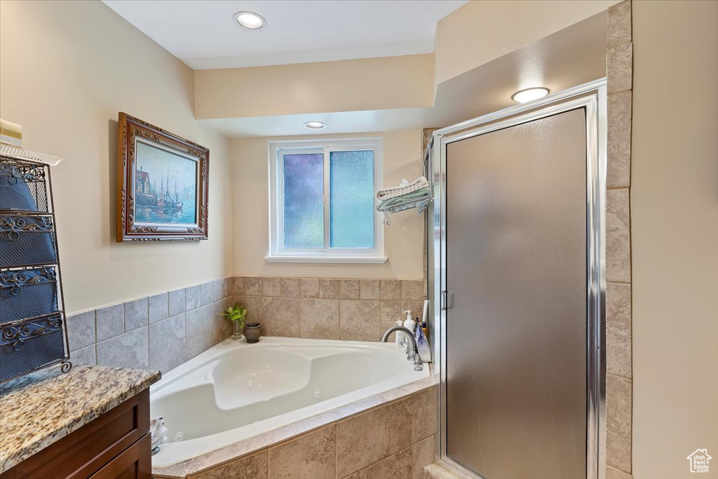 Bathroom with a bath, a shower stall, and vanity