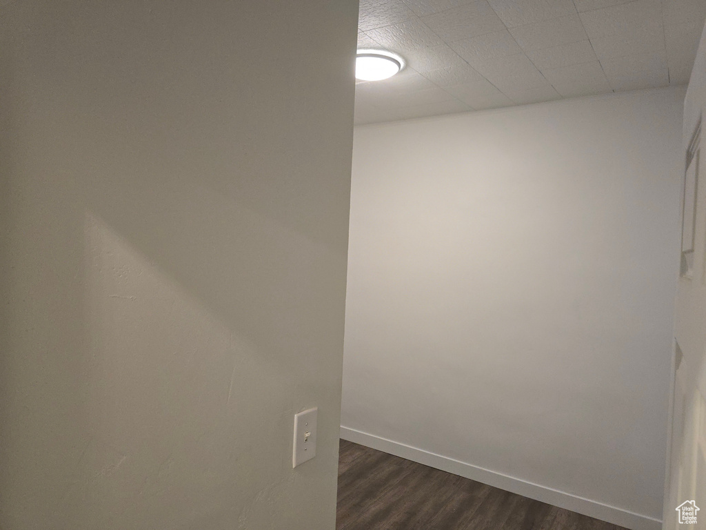 Spare room with dark wood-style floors and baseboards