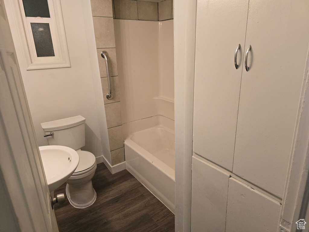 Full bathroom with toilet, wood finished floors, shower / tub combination, and baseboards