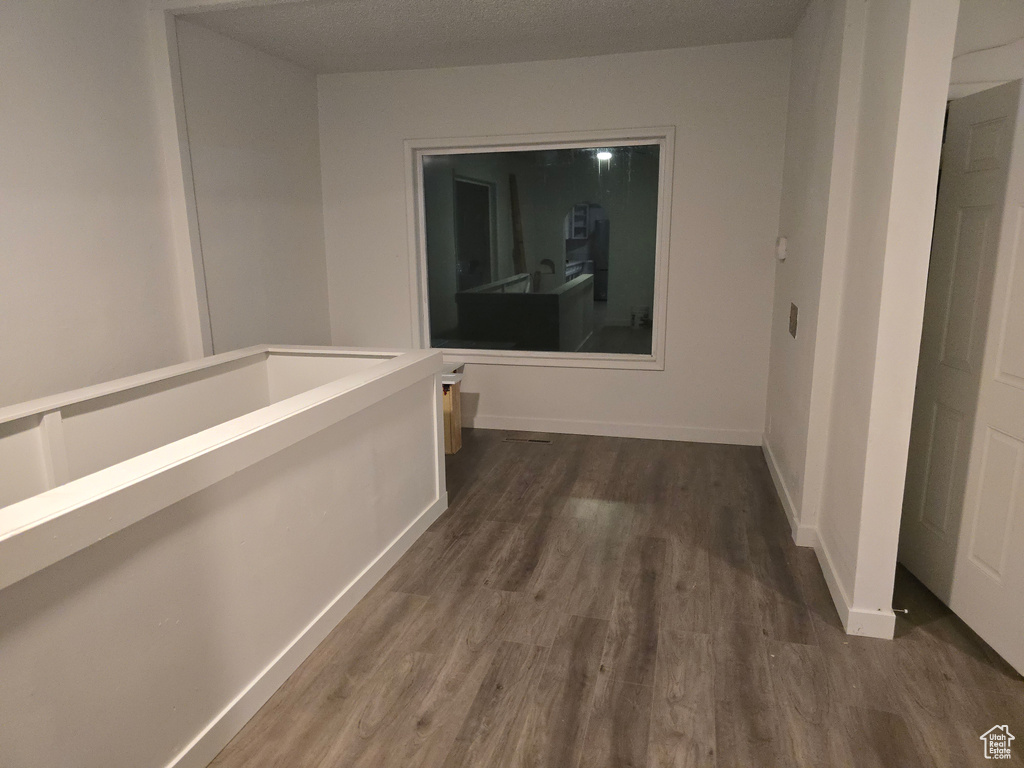 Hallway with dark wood-type flooring and baseboards
