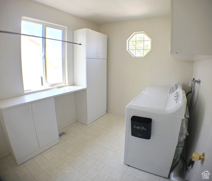 Washroom featuring cabinet space and washing machine and dryer