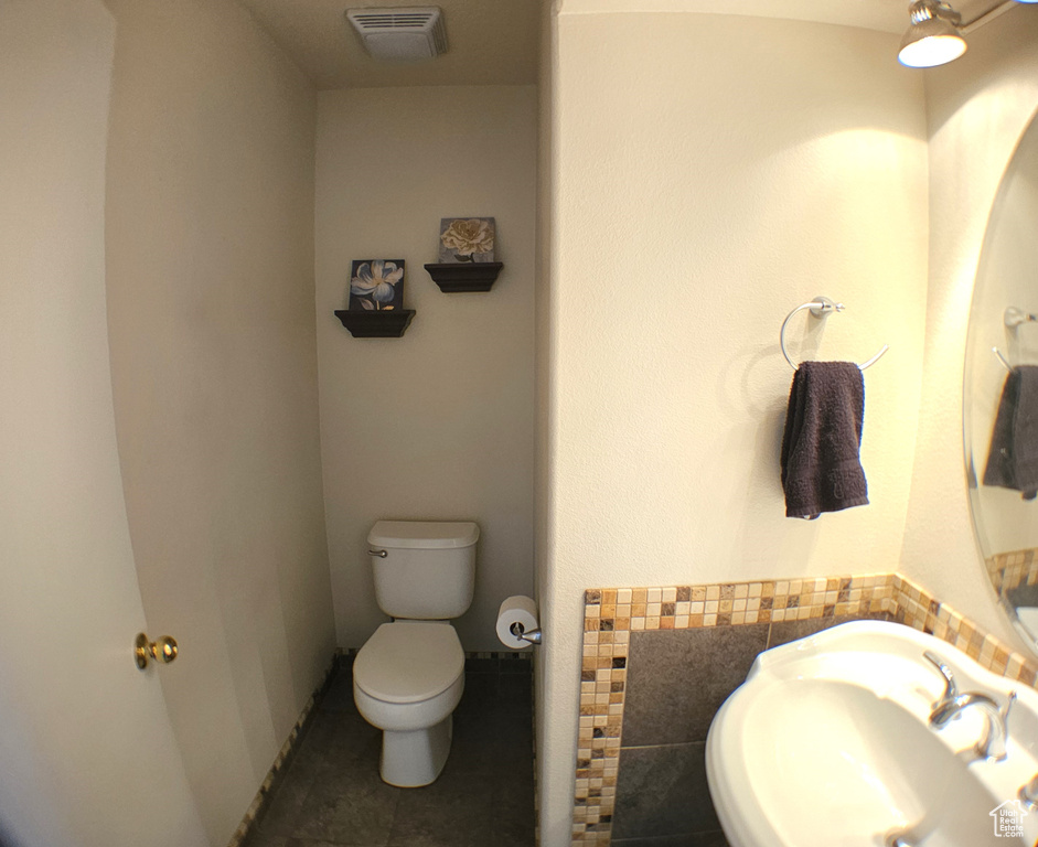 Bathroom featuring toilet, a sink, and tile patterned flooring