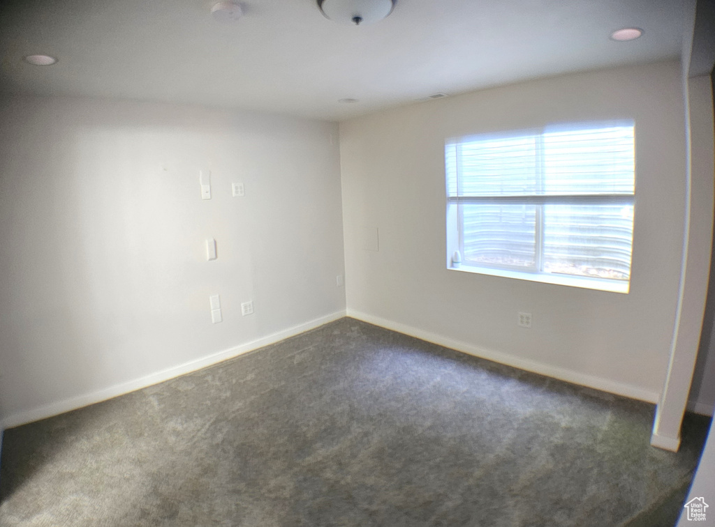 Unfurnished room with dark carpet, baseboards, and recessed lighting