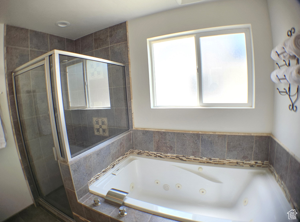 Bathroom with a shower stall and a whirlpool tub
