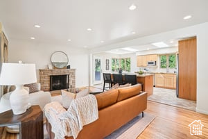 Living room with light wood-style floors, recessed lighting, a fireplace, and baseboards
