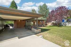 View of vehicle parking featuring a carport and driveway
