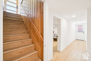 Stairway with wood finished floors and recessed lighting