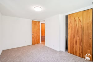 Unfurnished bedroom with carpet flooring and a closet
