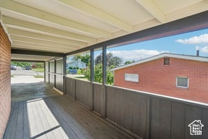 Unfurnished sunroom featuring beam ceiling