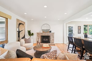 Living room with a fireplace, wood finished floors, and recessed lighting