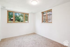 Carpeted spare room with baseboards