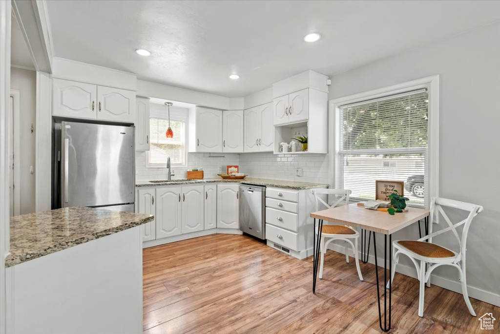 Kitchen featuring appliances with stainless steel finishes, a sink, white cabinetry, tasteful backsplash, and recessed lighting