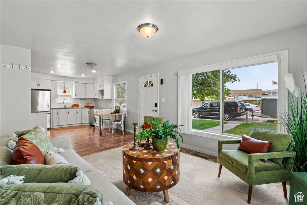 Living area with light wood-style flooring, baseboards, and recessed lighting