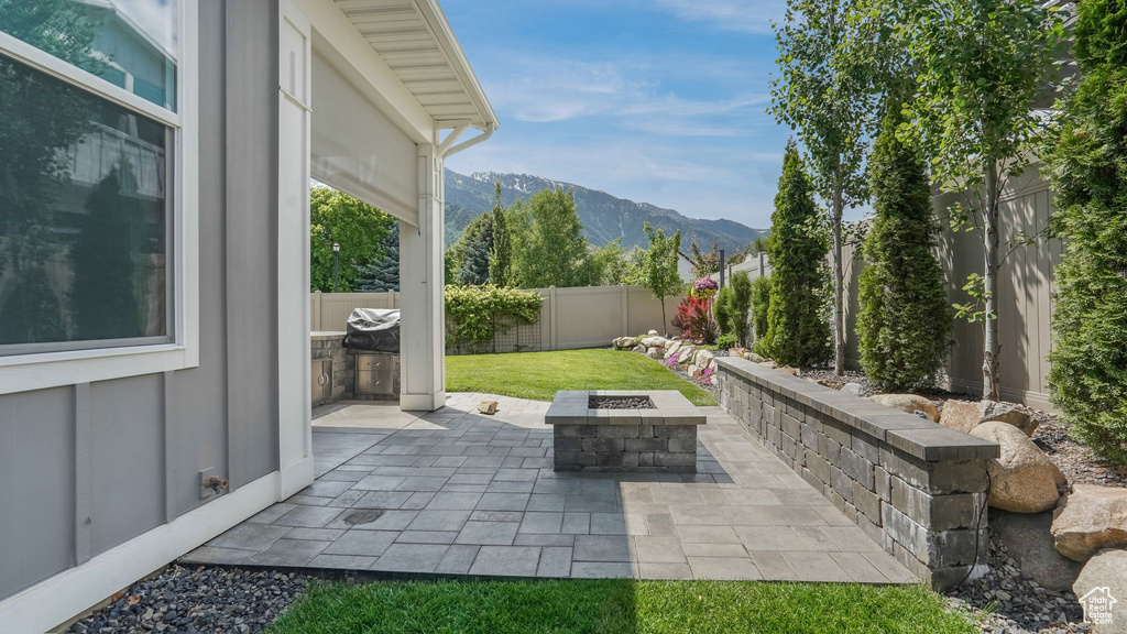 View of patio / terrace featuring an outdoor fire pit and a mountain view