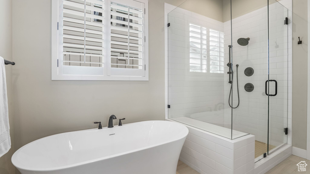 Bathroom with a stall shower and a freestanding bath