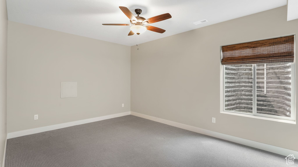 Unfurnished room with a ceiling fan, carpet floors, and baseboards