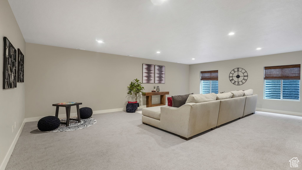 Carpeted living area with baseboards and recessed lighting