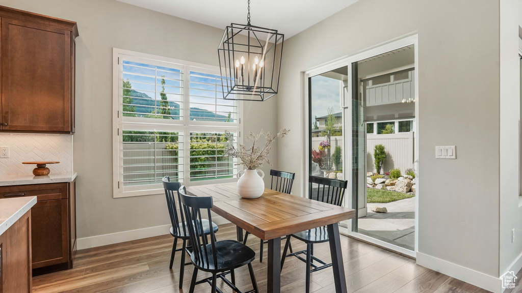 Dining room with baseboards, light wood-style floors, and a chandelier
