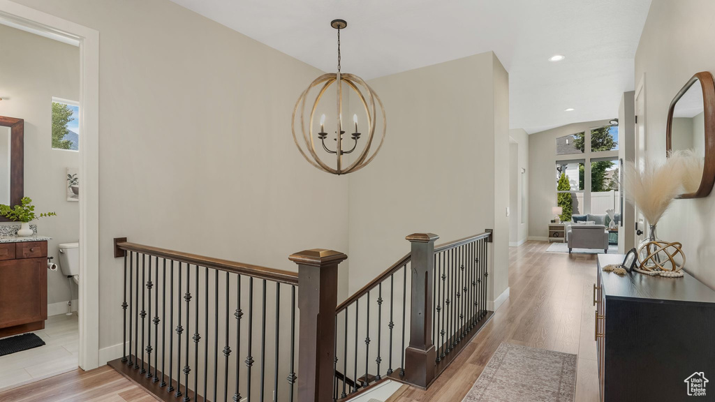 Hallway featuring an upstairs landing, a chandelier, light wood-type flooring, baseboards, and recessed lighting